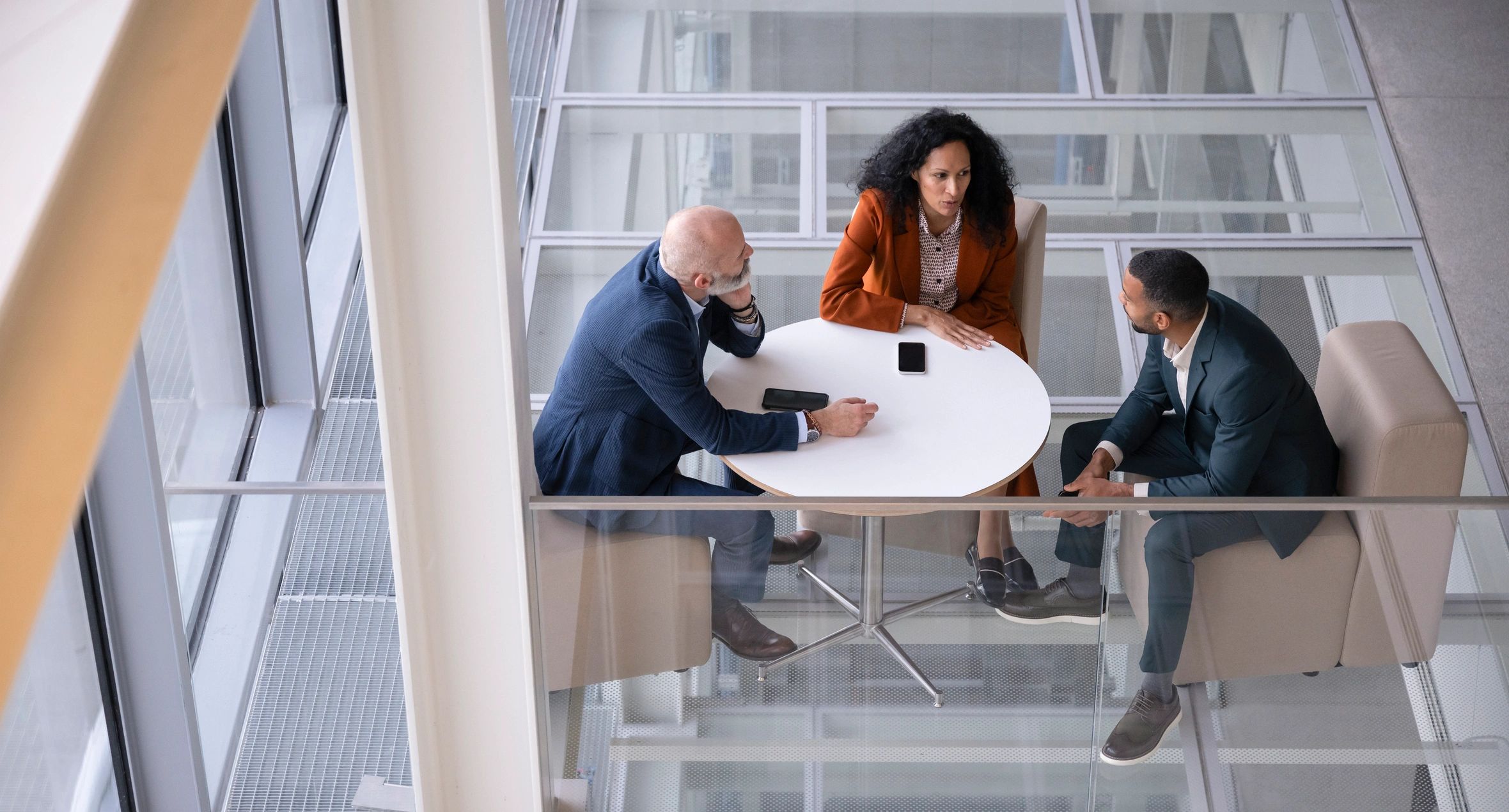 Aerial view of three professionals collaborating around a table